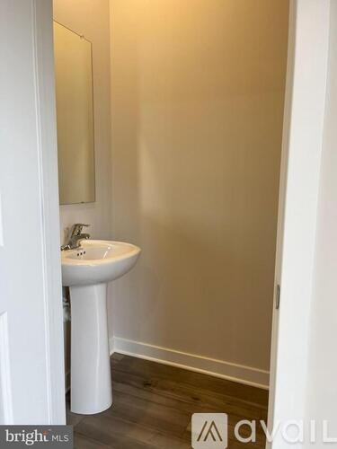 A white pedestal sink with a mirror above it.