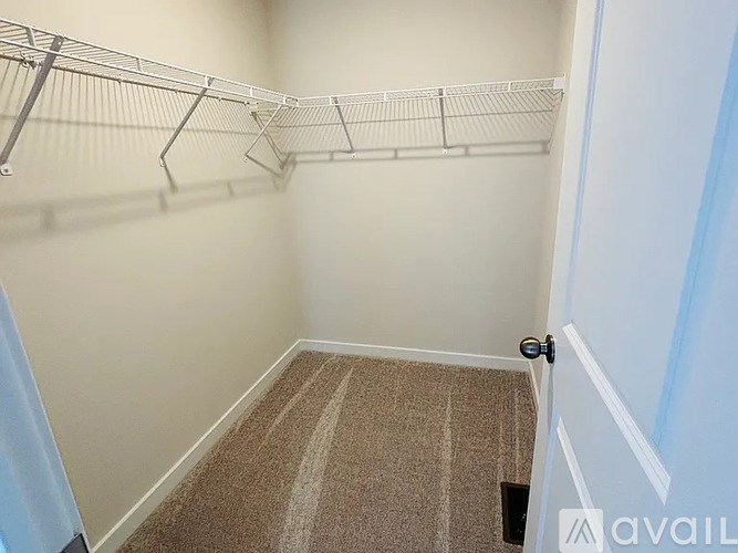 A small, empty room with a carpeted floor and a door on the right.