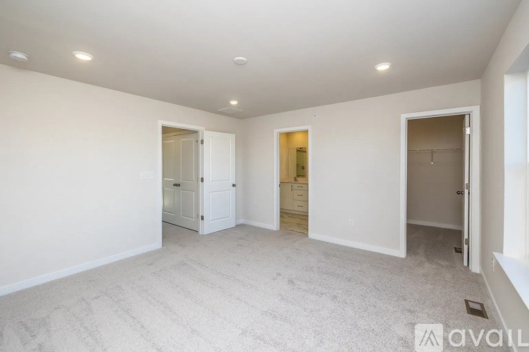A spacious room with white walls and carpeted floor.