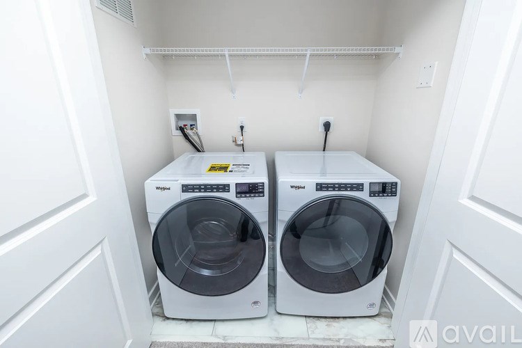 Two front load washing machines in a small laundry room.