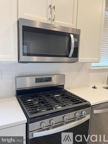 A stainless steel microwave oven is mounted above a stove in a kitchen.