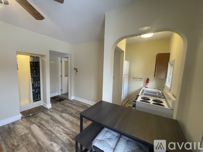 A living room with a dining table and a kitchen area in the background.