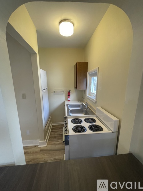 A kitchen with a stove top oven and a window.