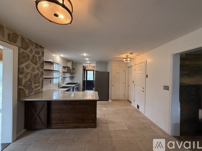 A kitchen with a stone wall and a counter with a brown drawer.