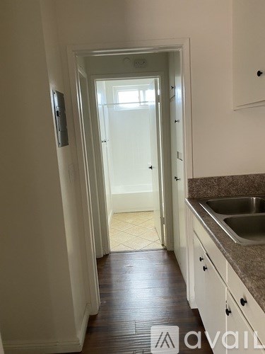 A kitchen with a sink and a doorway leading to a hallway.