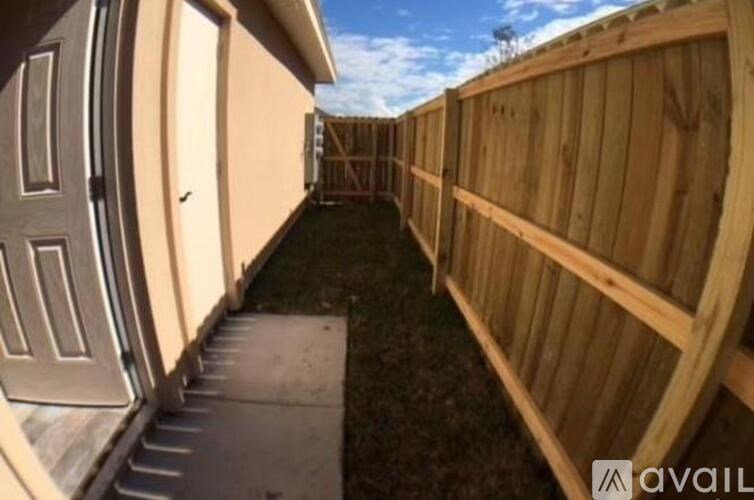 A wooden fence runs along the side of a house.