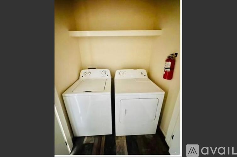 Two white washing machines in a small laundry room.