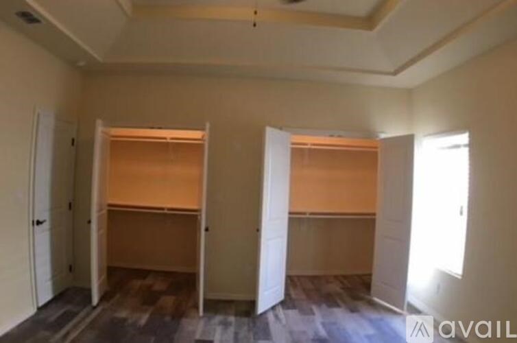 Two beds in a room with white walls and wooden floors.