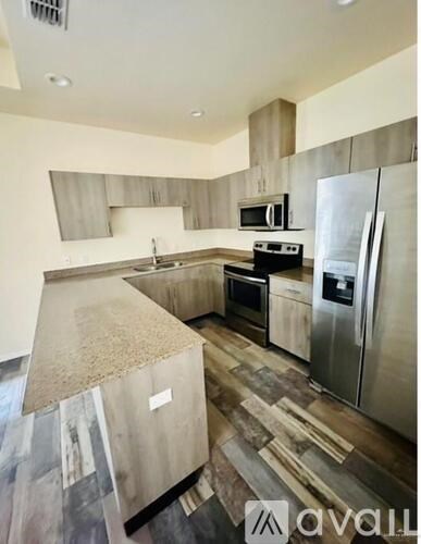 A kitchen with a refrigerator, oven, and microwave.