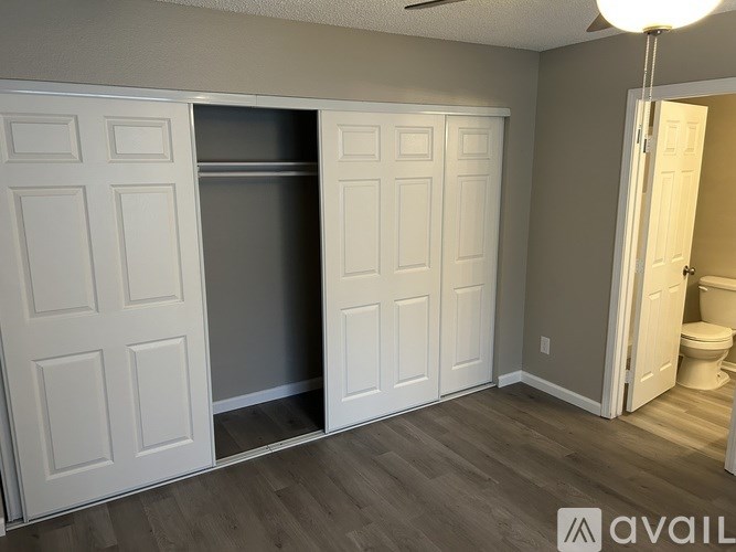 A room with a white door and a wooden floor.