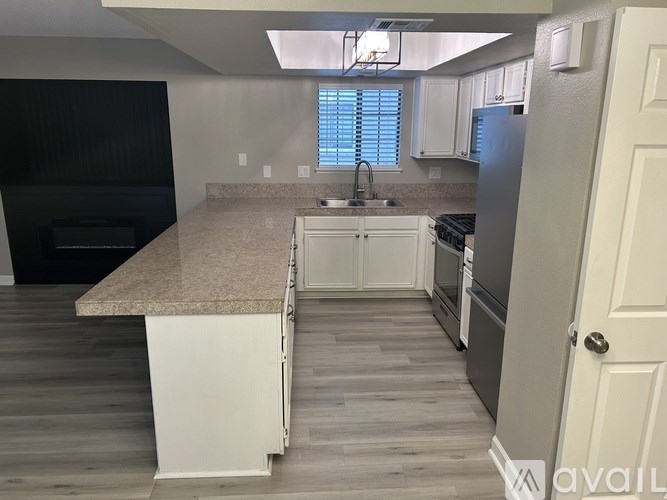 A kitchen with a granite countertop and white cabinets.