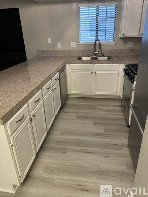 A kitchen with white cabinets and a granite countertop.