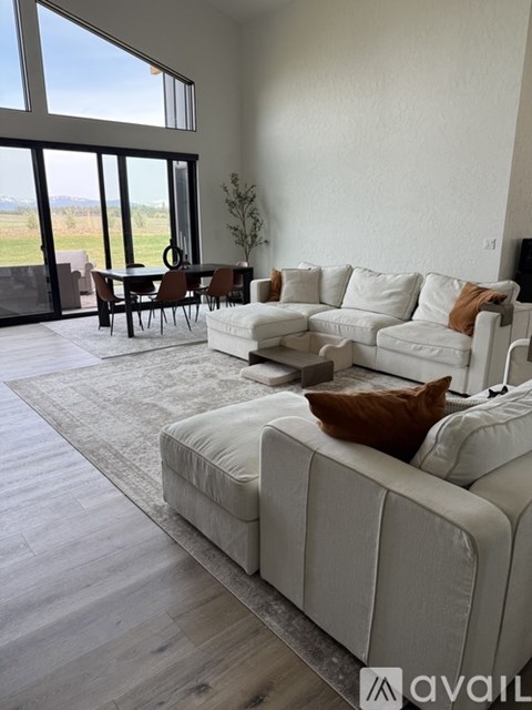 A living room with a white couch and a dining table.