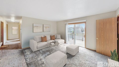 A living room with a grey carpet and a white sofa.
