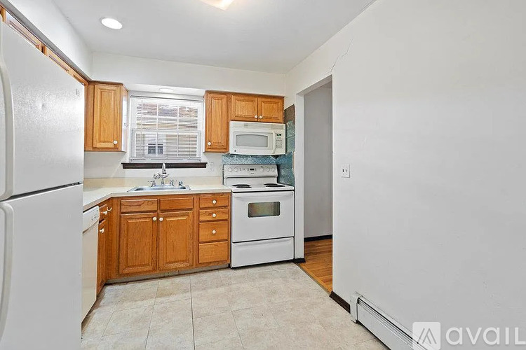 A kitchen with wooden cabinets and white appliances.