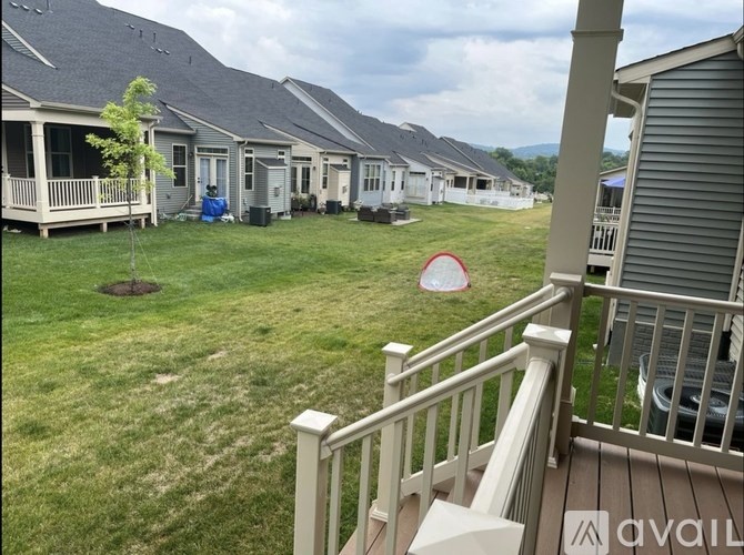 A grassy area with a few houses and a tree.