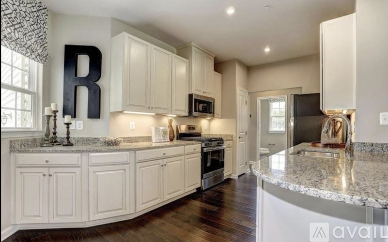 A kitchen with white cabinets and a large island.