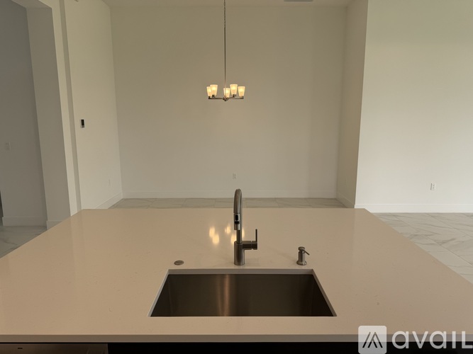 A modern kitchen with a sink and a chandelier.