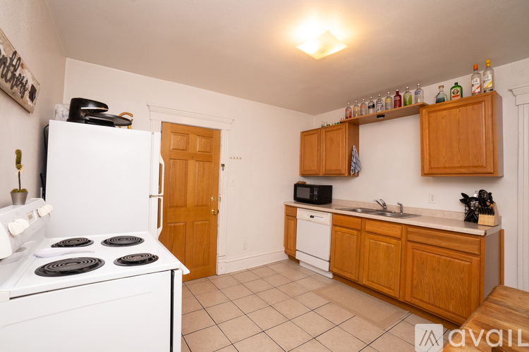 A kitchen with white appliances and wooden cabinets.