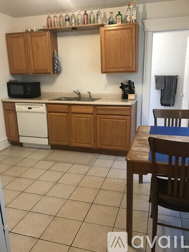 A kitchen with wooden cabinets and a white dishwasher.