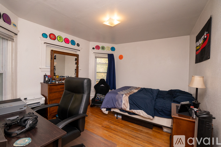 A bedroom with a bed, chair, and a desk with a computer.
