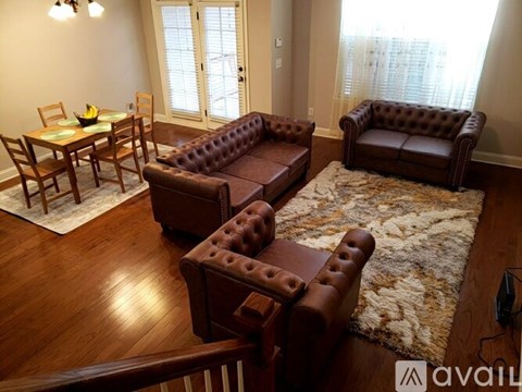 A brown leather couch and chair set in a living room.