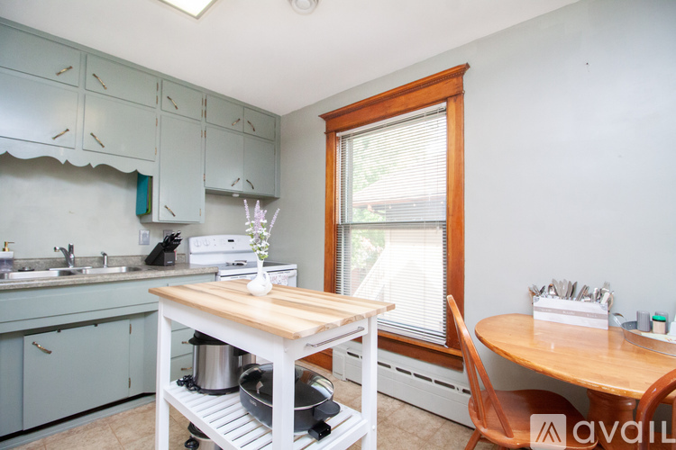 A kitchen with a table and chairs in front of a window.