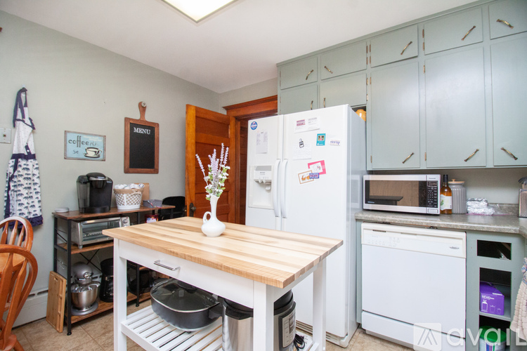 A kitchen with a white fridge and wooden table.