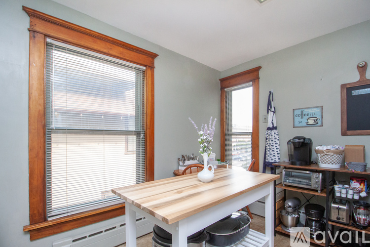 A kitchen with a table and a window with blinds.