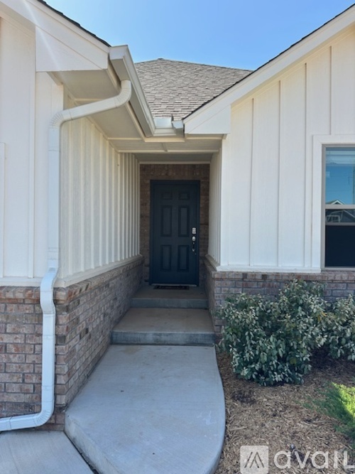 A house entrance with a black door and a white wall.