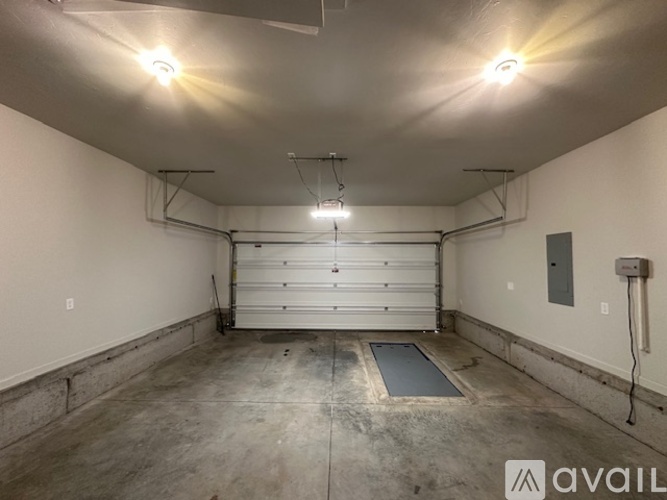 A spacious garage with a white door and concrete floor.