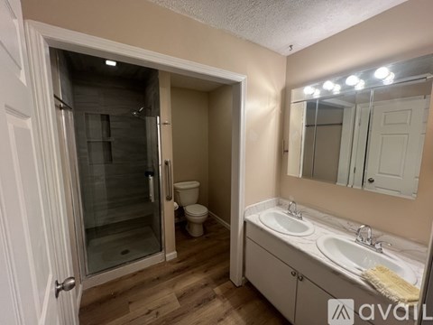 A bathroom with a toilet, sink, and shower.