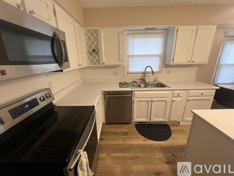A kitchen with a black stove top oven and white cabinets.