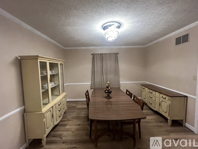 A dining room with a wooden table and chairs.