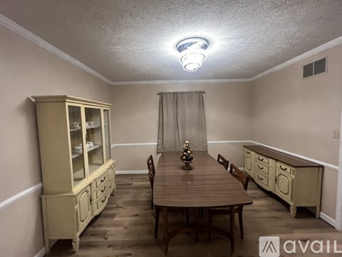 A dining room with a wooden table and chairs.