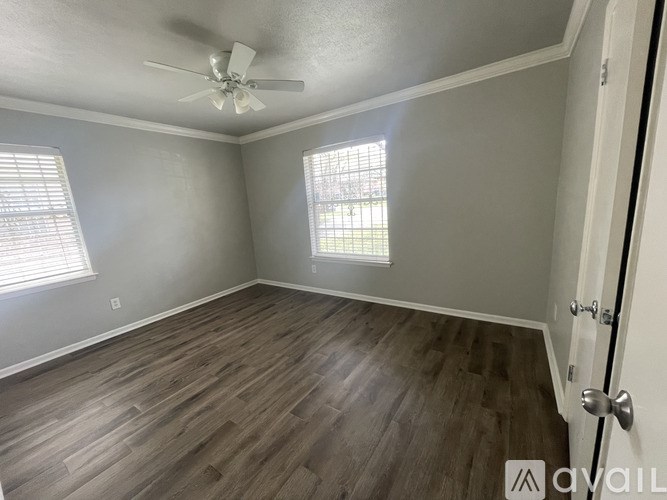 A room with a ceiling fan and wooden flooring.