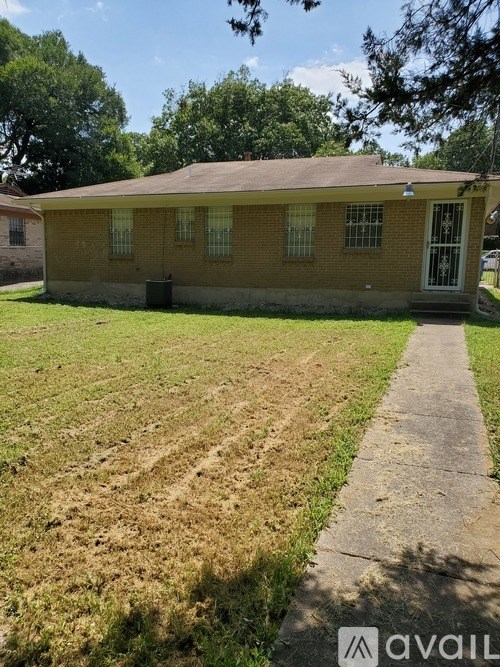 A small yellow house with a brown roof and a white door.