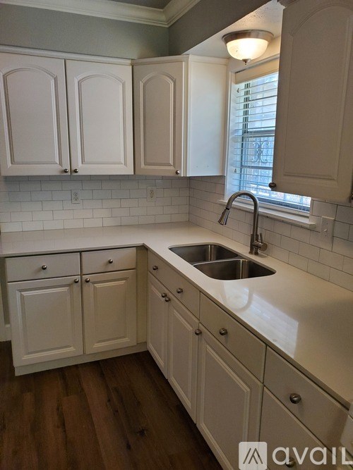A kitchen with white cabinets and a sink.