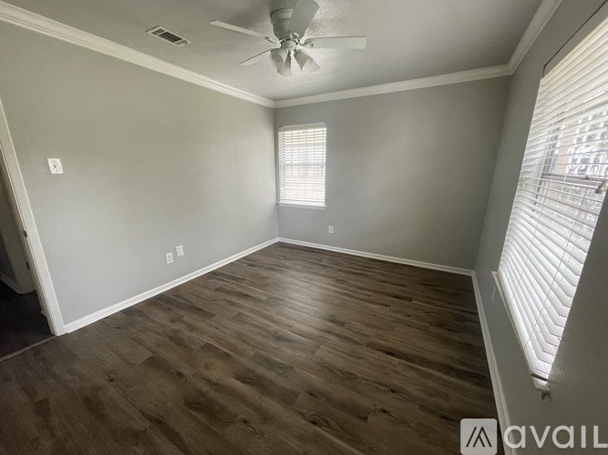 A room with wooden flooring and a ceiling fan.