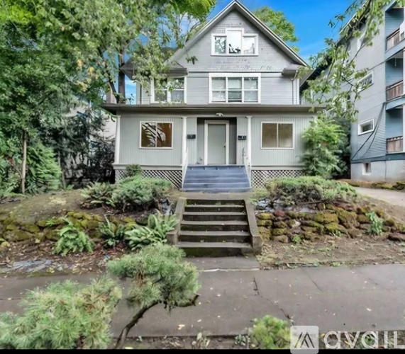 A house with a front yard and stairs leading to the front door.
