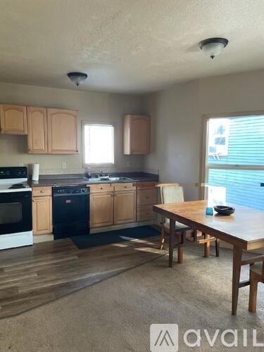 A kitchen with wooden cabinets and a dining table.