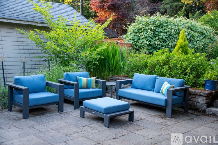A set of blue outdoor furniture is arranged on a patio.