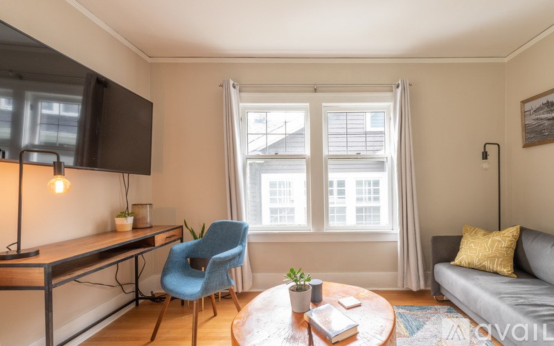 A living room with a blue chair and a grey couch.