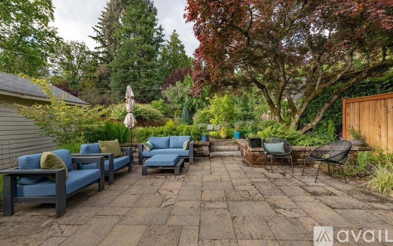 A patio with a table and chairs surrounded by trees.