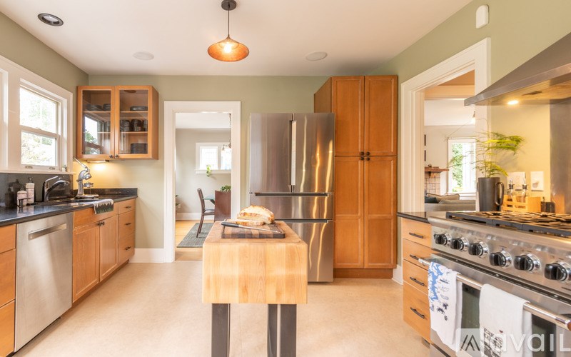 A kitchen with wooden cabinets and a stainless steel refrigerator.