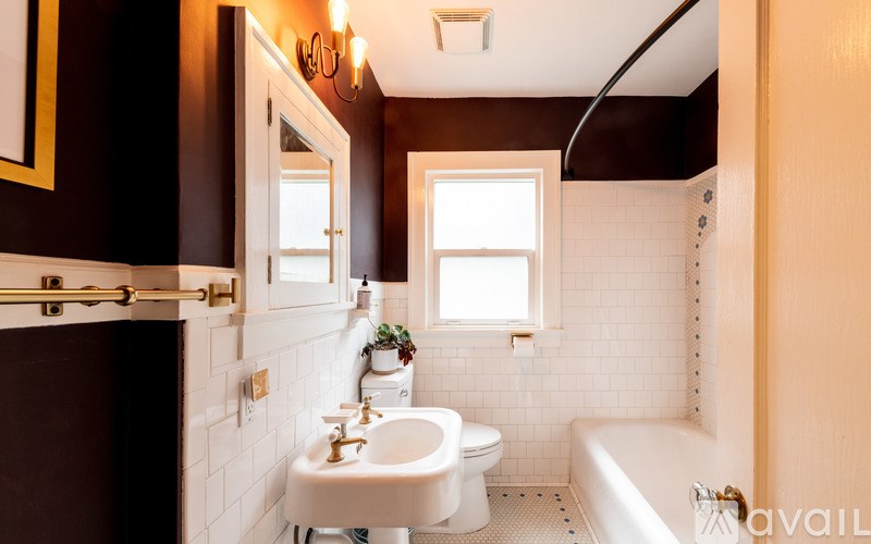 A bathroom with a white sink and a white toilet.