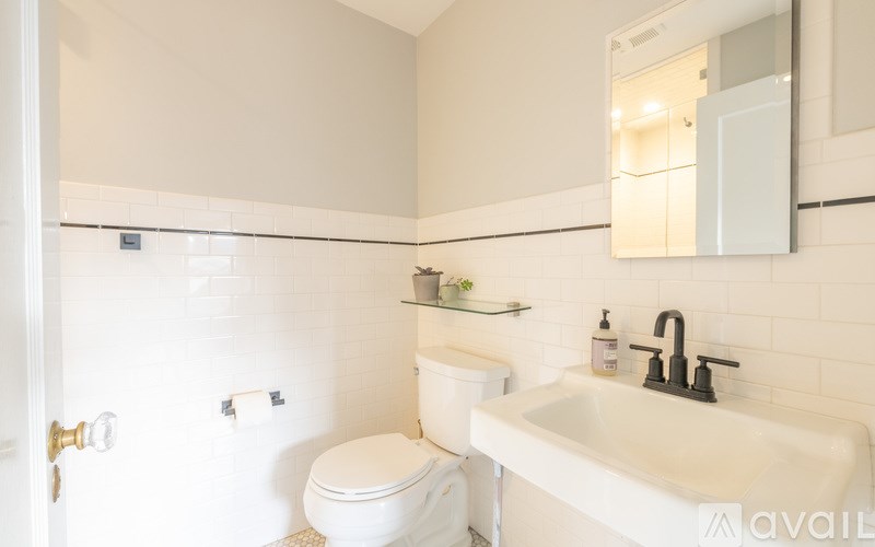 A white toilet sits next to a white sink in a bathroom.