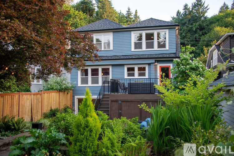 A blue house with a red door and a wooden fence.