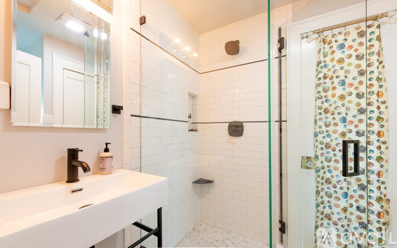 A white sink with a black faucet in a bathroom.