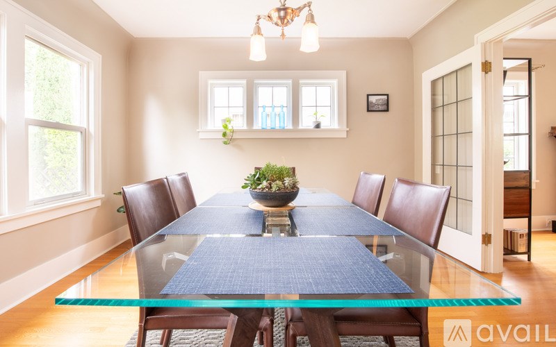A dining room with a glass table and chairs.